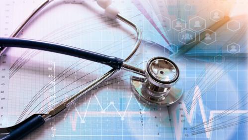 Stethoscope on desk with pen and graphs